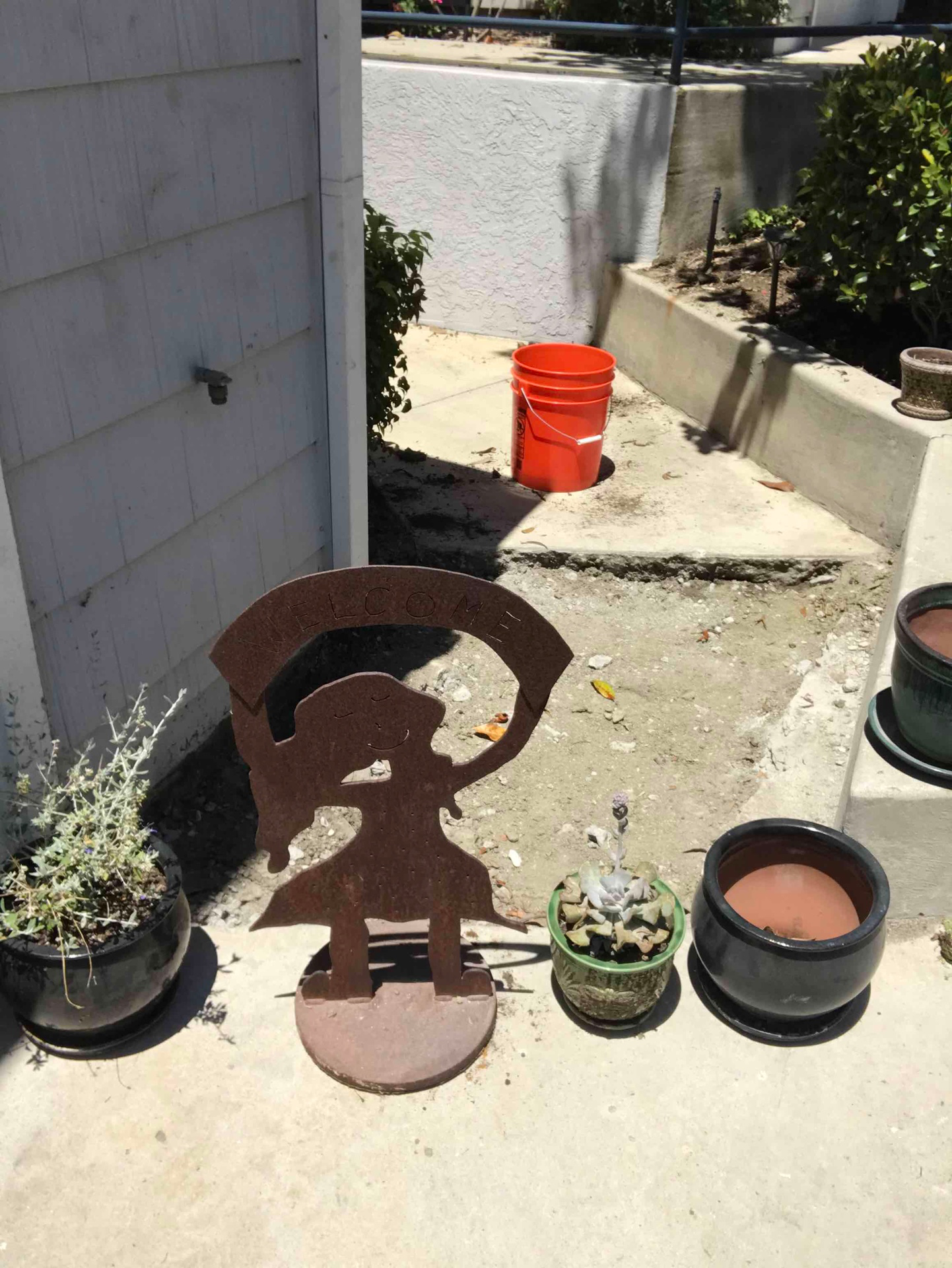 Localized concrete opening beside retained concrete and a wall or curb before restoration